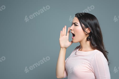 Preview: attractive emotional girl gesturing and yelling, isolated on grey