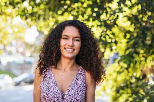 Preview: Portrait of a cheerful Latin American young woman outdoors