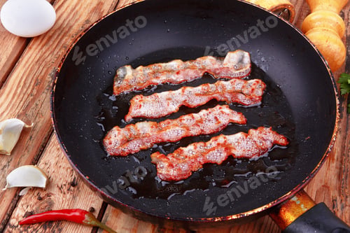 Preview: Fried bacon in a frying pan