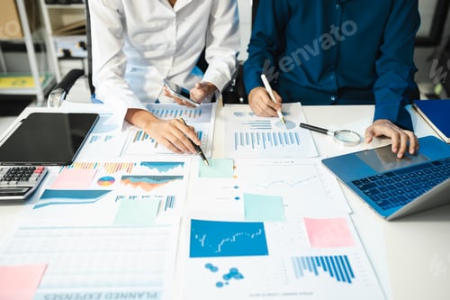 Preview: financial asian advisor showing plan of investment to clients in the consultancy office.