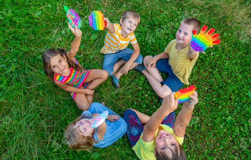 Preview: Children play anti-stress popit on the street. Selective focus.