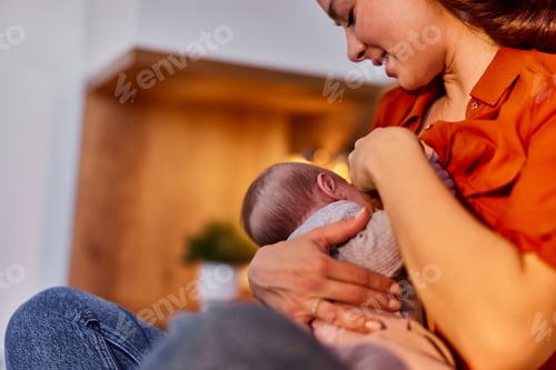 Preview: A woman sits with her legs crossed and feeds a baby breast milk at home.