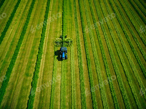 Preview: Aerial view of Tractor mowing green field in Finland.