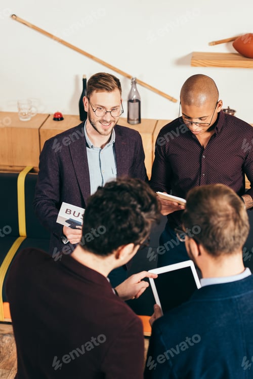 Preview: high angle view of group of young multicultural businessmen in cafe