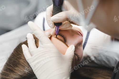 Preview: A cosmetologist applies permanent makeup to the eyebrows - eyebrow tattoo. eyebrow perm