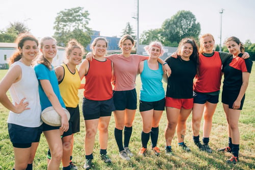 Preview: A diverse team of female athletes posing together with confidence on the field.
