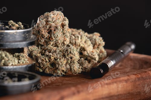 Preview: Detail of dried cannabis bud isolated over black background on a wooden surface