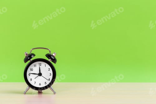 Preview: Vintage black alarm clock on a bright green background
