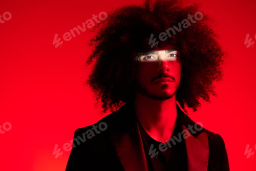 Preview: Fashion portrait of a man with curly hair on a red background, multinational, colored light, trendy
