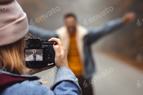 Preview: Couple spending time together walking on forest road on photographing each other a foggy morning.