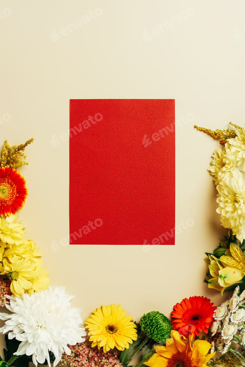 Preview: flat lay with various beautiful flowers and blank red card on beige background