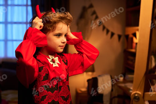 Preview: Boy putting on headband with red horns