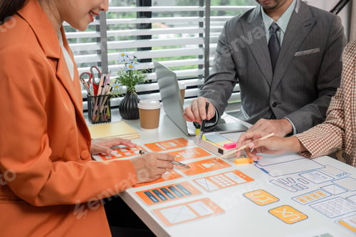 Preview: Creative Team Collaborates on UX UI Design Project in Modern Office Setting with Laptops and Design