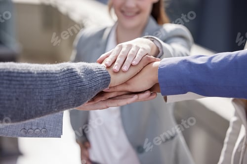 Preview: Shot of a group of unrecognizable businesspeople stacking their hands together outside