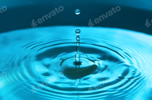 Preview: Water drop falling into water making a perfect concentric circles. Abstract blue background
