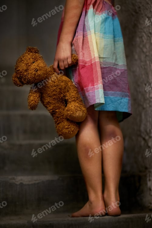 Preview: Abused and alone. Cropped view of a little girl holding a teddy bear.