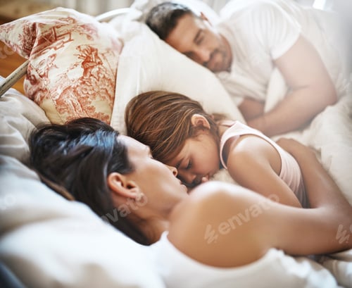 Preview: In the middle is where shell stay. Shot of a family sleeping in bed at home.