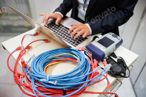Preview: Mid Section Of Technician Using Laptop In Server Room