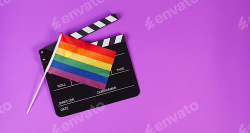 Preview: Clapper board and rainbow pride flag on purple background