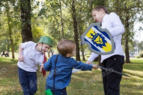 Preview: Caucasian boys play war in a public park in summer. Military battle game.