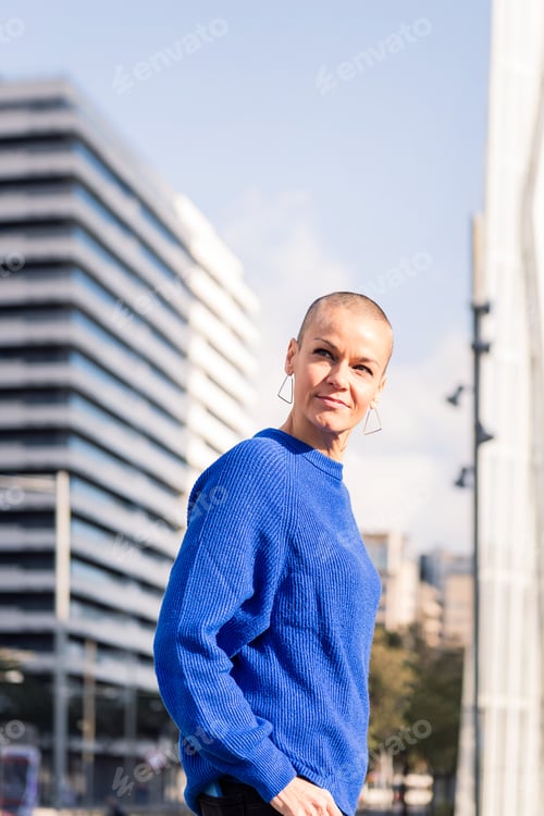 Preview: woman with shaved head strolling city streets