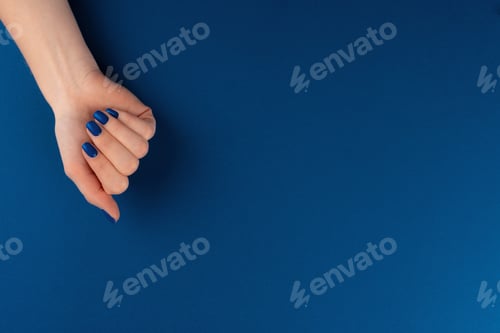 Preview: Female hands with manicure of classic blue color on blue background
