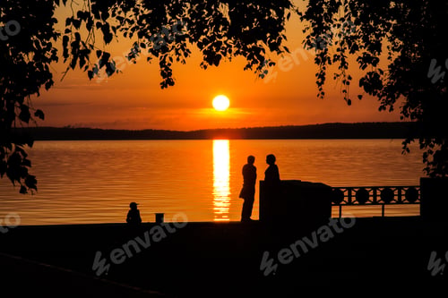 Preview: Silhouette of a couple in love and child at sunset or sunrise