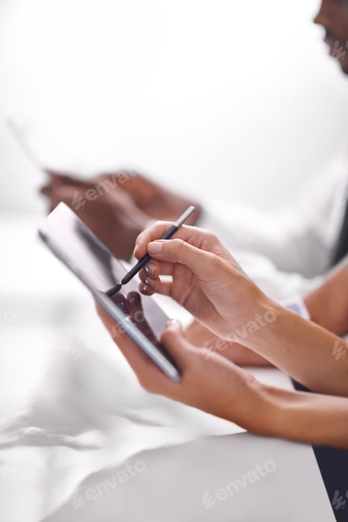Preview: Cropped shot of two businesspeople using their touchpads