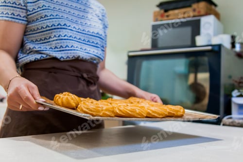 Preview: confectioner make eclairs with cream