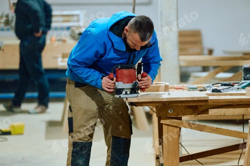 Preview: Close Up of Worker Carefully Cutting and Planing Wooden Pieces for Furniture in Wood Industry