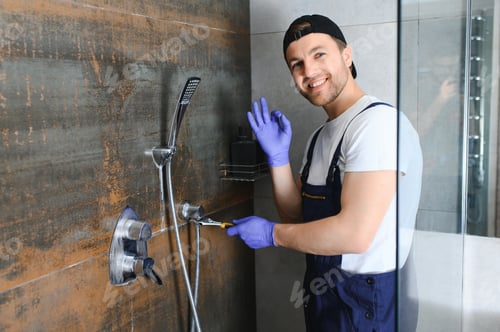 Preview: Professional handyman working in shower booth indoors