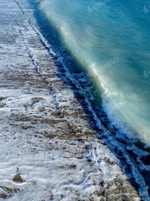 Preview: Aerial view of ocean waves breaking on a sandy beach. Nature background