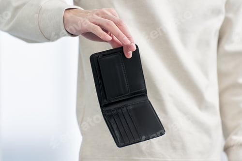Preview: A man holding a wallet with no money in it