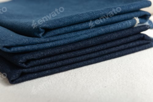 Preview: stack of folded natural dark blue color denim fabric.