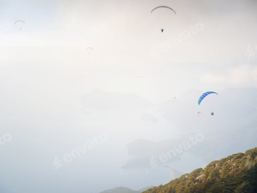 Preview: Paragliding in sky. Paraglider tandem flying over sea and mountains