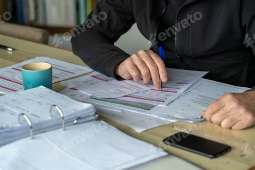 Preview: Man working at his desk at home, studying energy bills