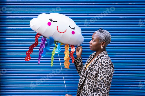 Preview: Side view of African American female with short hair in stylish wear standing on blue background