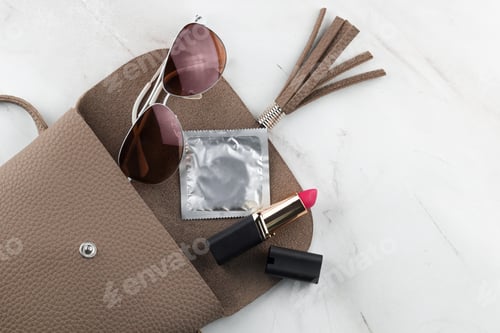 Preview: Top view of the contents of a women's bag,open bag,marble background.