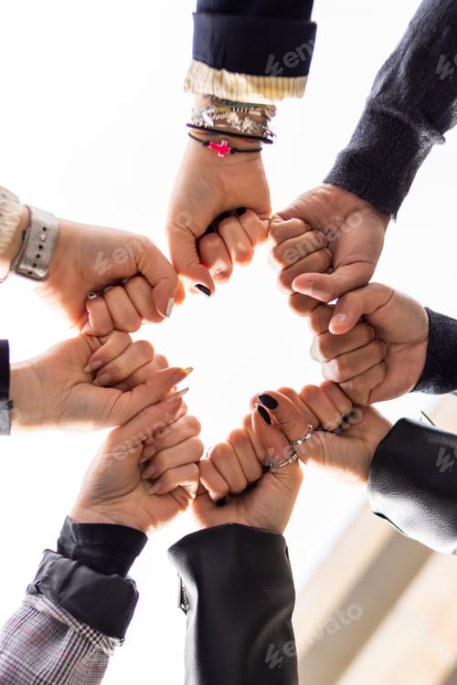 Preview: Low angle of group of people bumping fists. Togetherness and togetherness concept