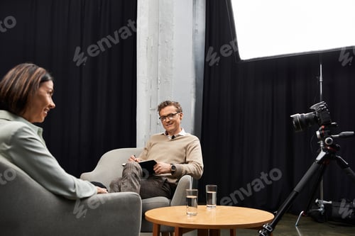 Preview: A thoughtful journalist discusses insights with a specialist in a cozy studio setting
