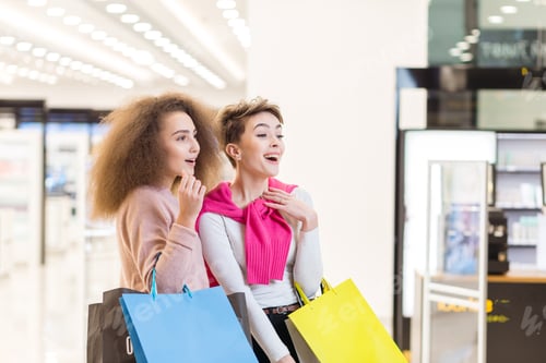 Preview: Couple of diverse women looking at smth in shop showcase in the department store