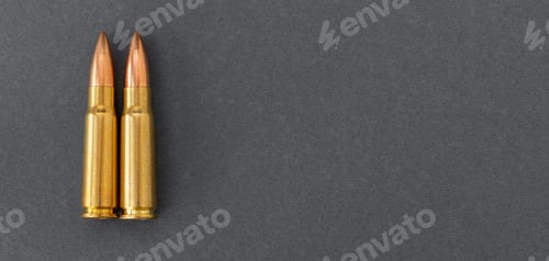 Preview: Two bullets on gray paper background. Cartridges 7.62 caliber for Kalashnikov assault rifle