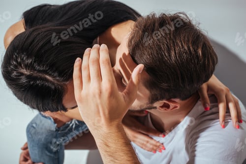 Preview: top view of young couple kissing while man hiding faces with hand