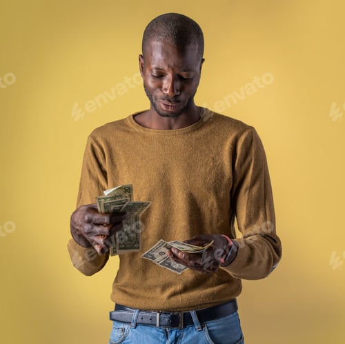 Preview: Young man counting cash savings and planning personal budget on yellow background