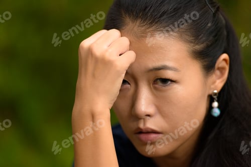 Preview: Close-up portrait of beautiful rebel Asian woman face outdoors