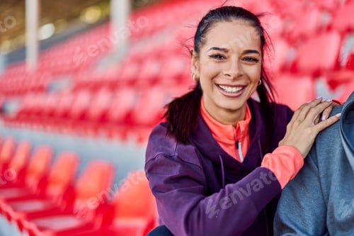 Preview: Smiling Young Woman in Sports Attire at Outdoor Stadium Seating