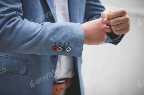 Preview: Shallow focus of a man in a suit fixing a watch on his wrist