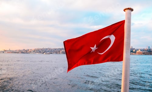 Preview: The Turkish flag flutters in the wind against the background of the sunset Bosphorus.
