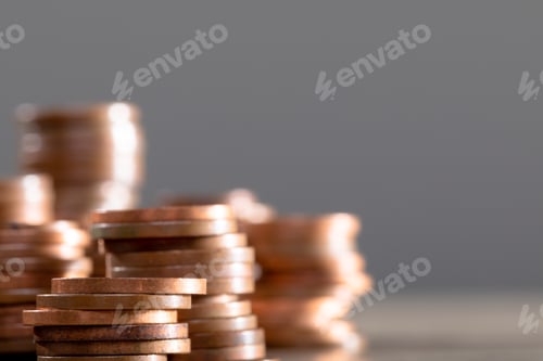 Preview: Close up of piles of coins on table, isolated on grey background