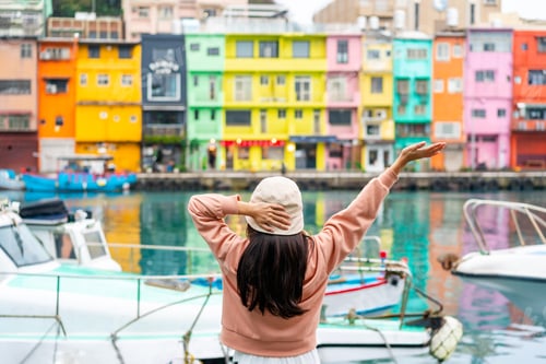 Preview: Young female tourist relaxing and enjoying the beautiful colorful Zhengbin Fishing Port in Taiwan